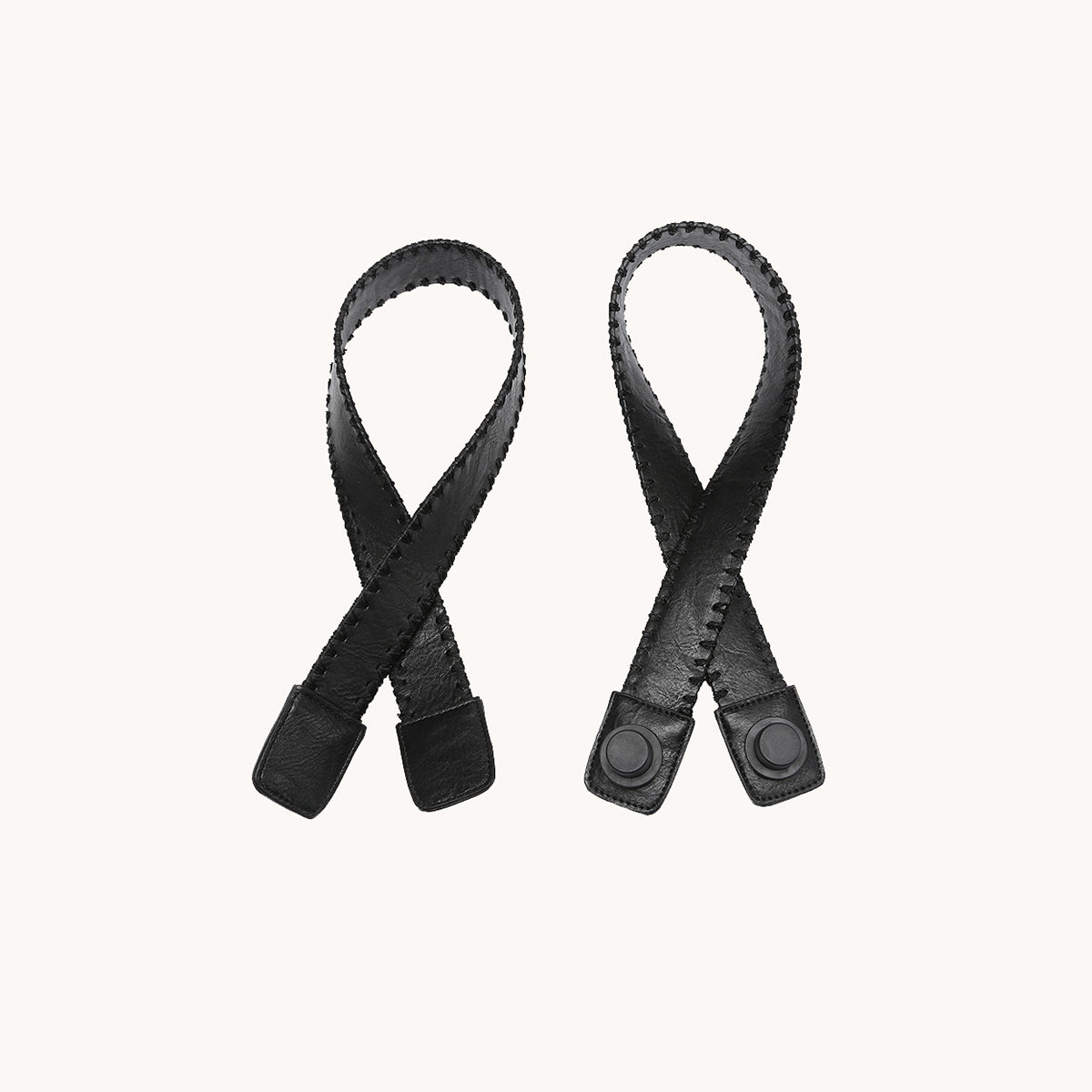 Pair of black stitched trim straps with adjustable ends and snaps